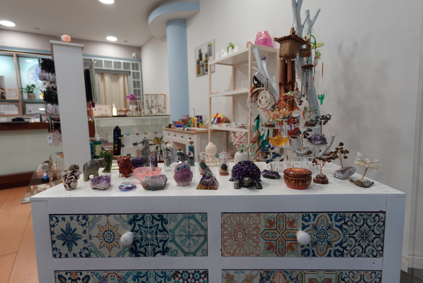 Mesa central com cristais, orgonites e árvores de pedras
